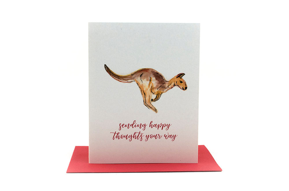 Greeting card standing upright on top of a colorful envelope against a white background.