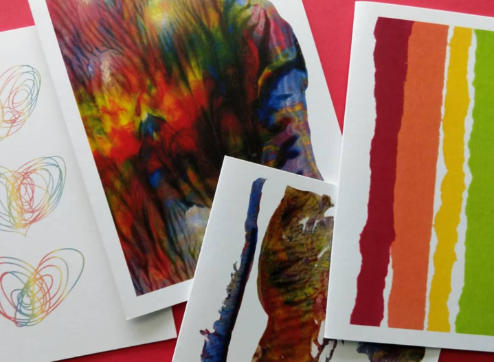 Four greeting cards overlapping on a red background.