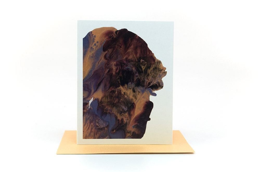 Greeting card standing upright on top of a colorful envelope against a white background.