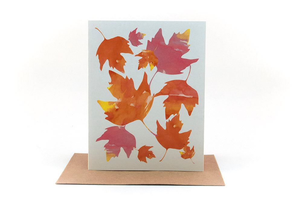 Greeting card standing upright on top of a kraft envelope against a white background.