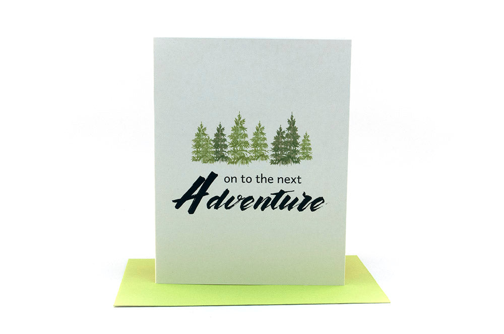 Greeting card standing upright on top of a colorful envelope against a white background.