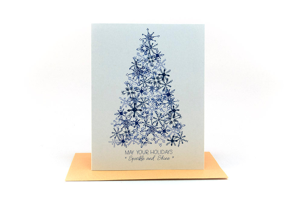 Greeting card standing upright on top of a colorful envelope against a white background.