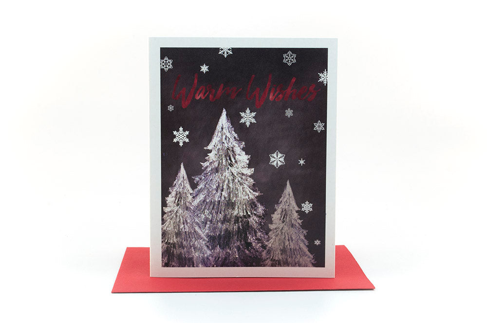 Greeting card standing upright on top of a colorful envelope against a white background.