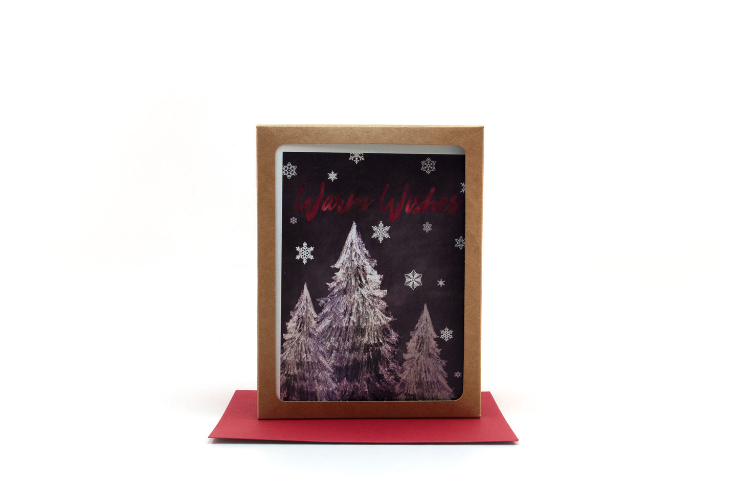 Greeting cards in a kraft box standing upright on top of a colored envelope against a white background.