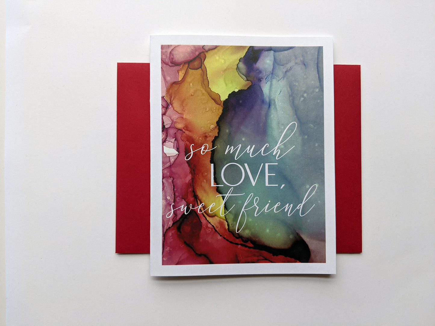 Greeting card laying on a white background with colorful envelope.