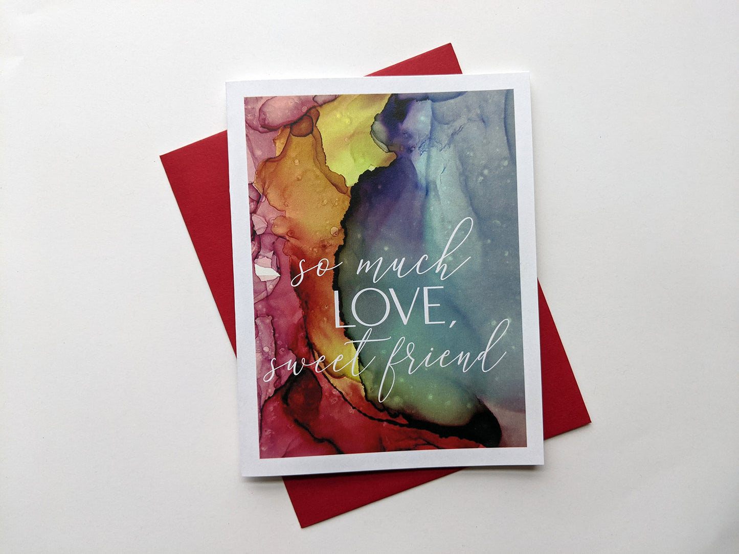 Greeting card laying on a white background with colorful envelope.