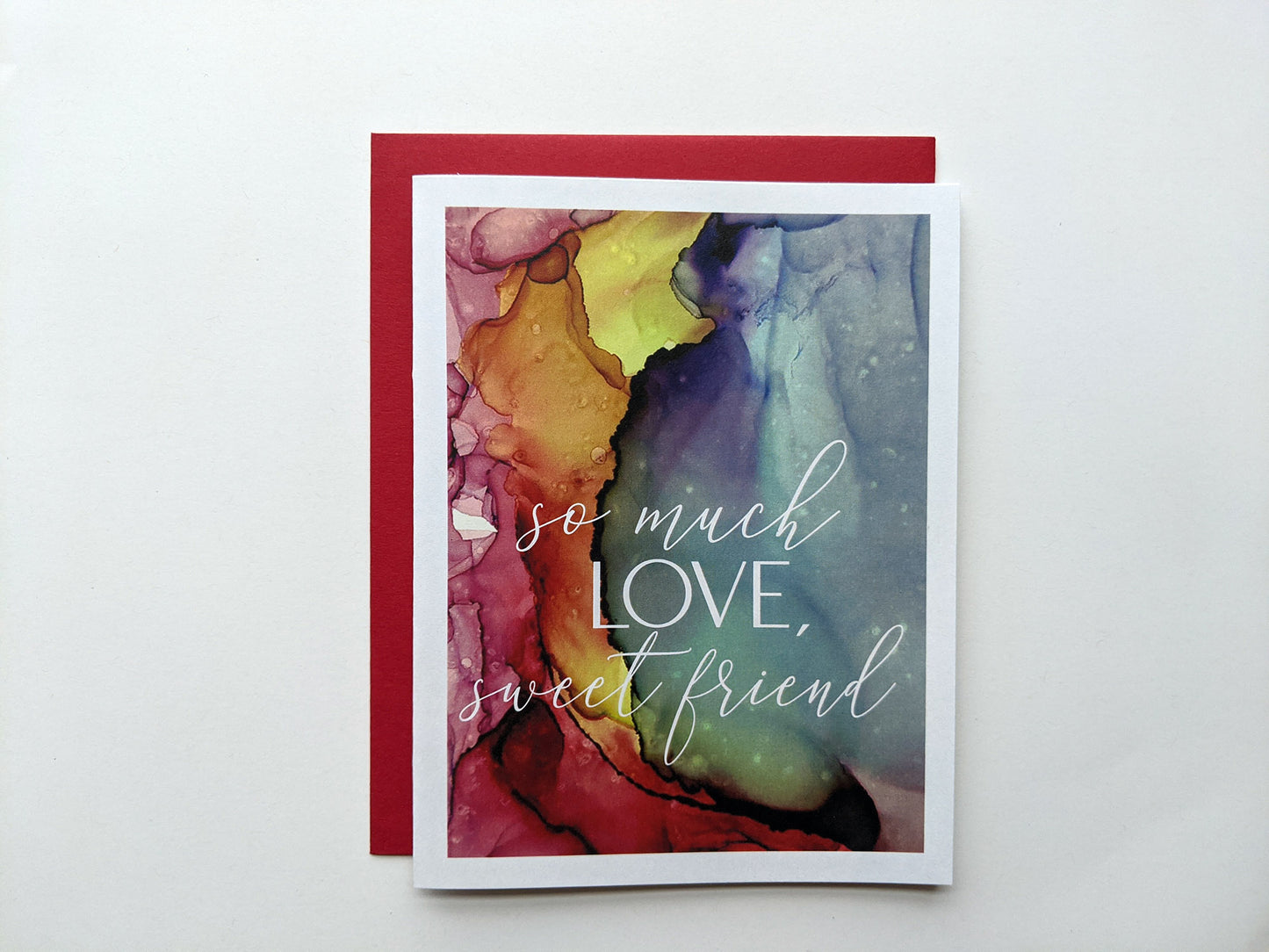 Greeting card laying on a white background with colorful envelope.