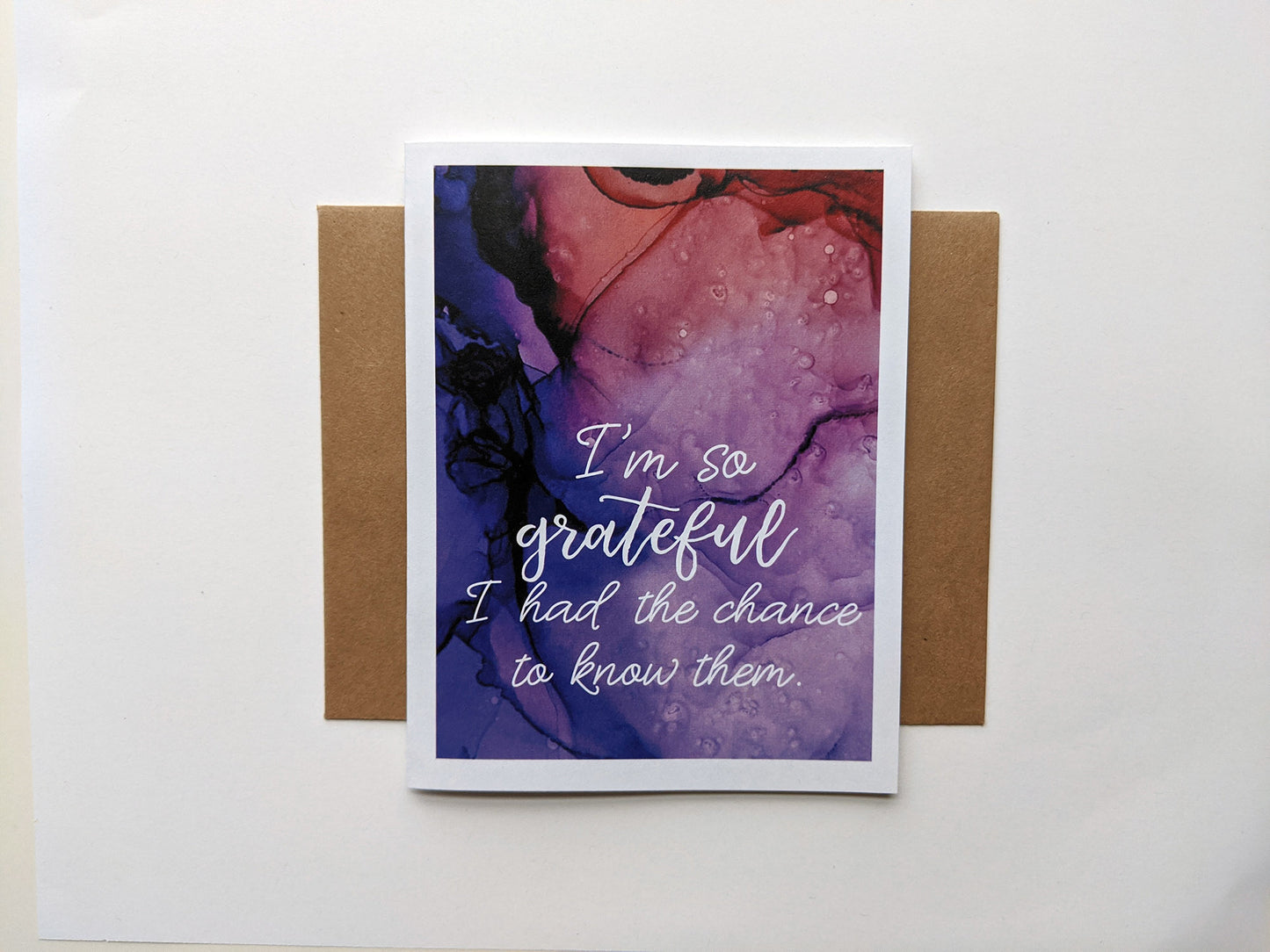 Greeting card laying on a white background with a kraft envelope.