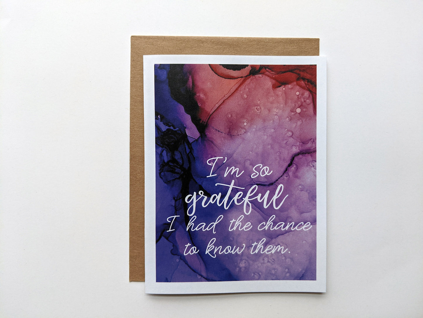 Greeting card laying on a white background with a kraft envelope.