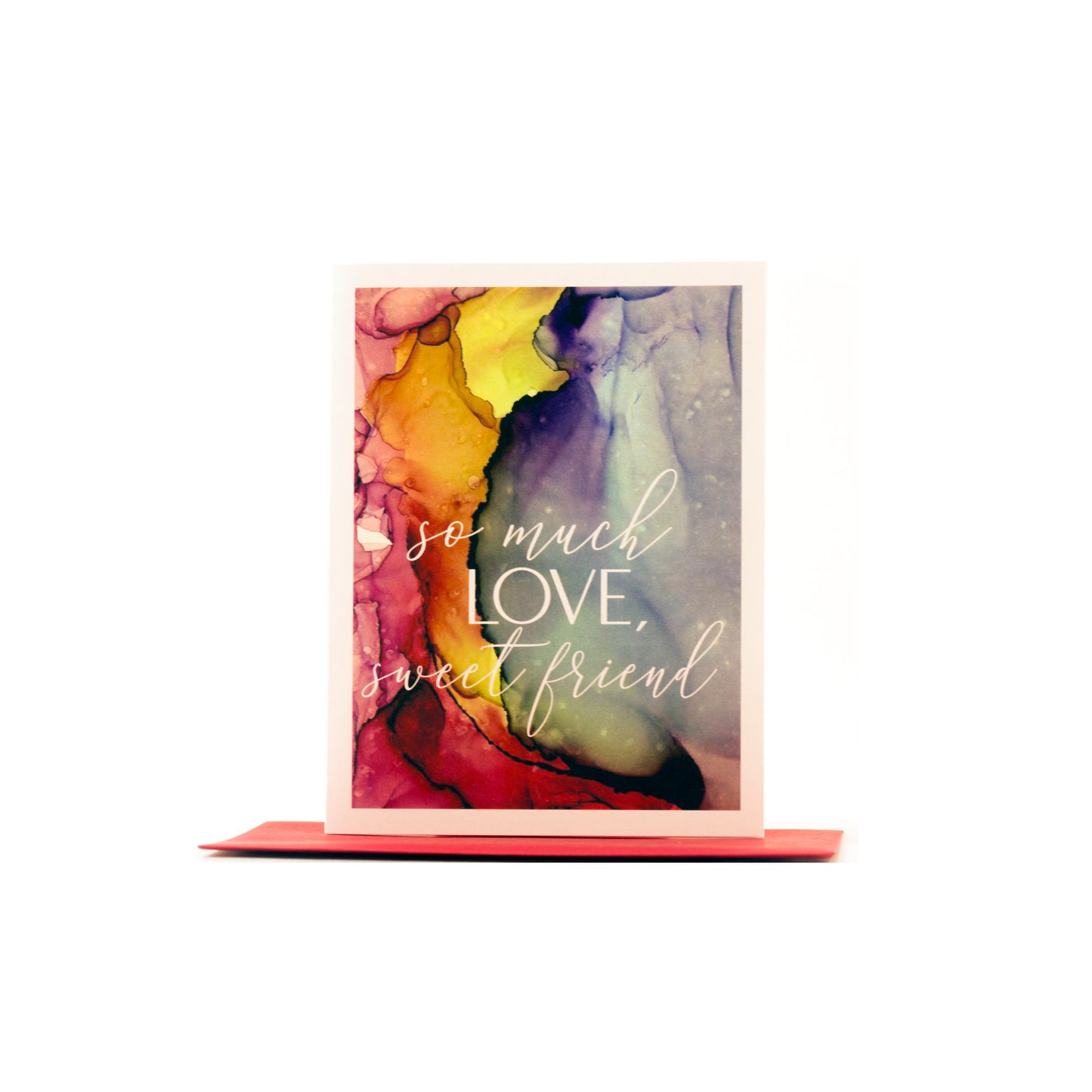 Greeting card standing upright on top of a colored envelope against a white background.