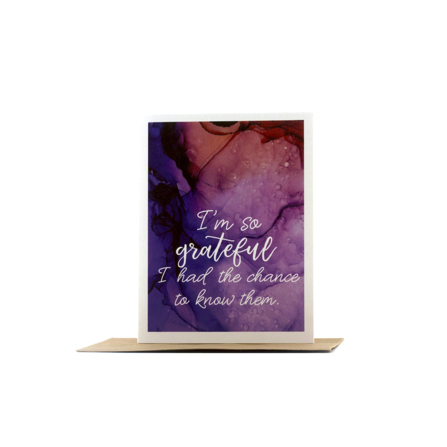 Greeting card standing upright on top of a kraft envelope against a white background.