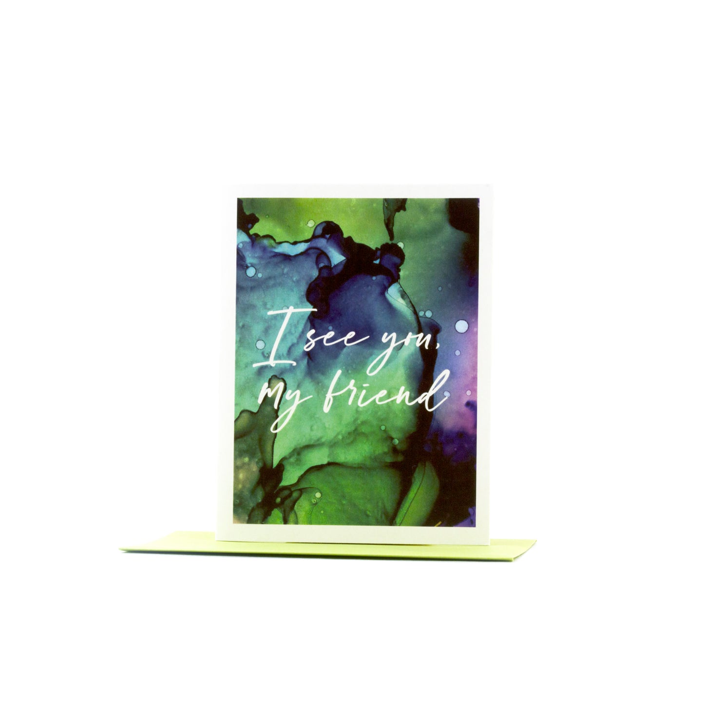 Greeting card standing upright on top of a colored envelope against a white background.