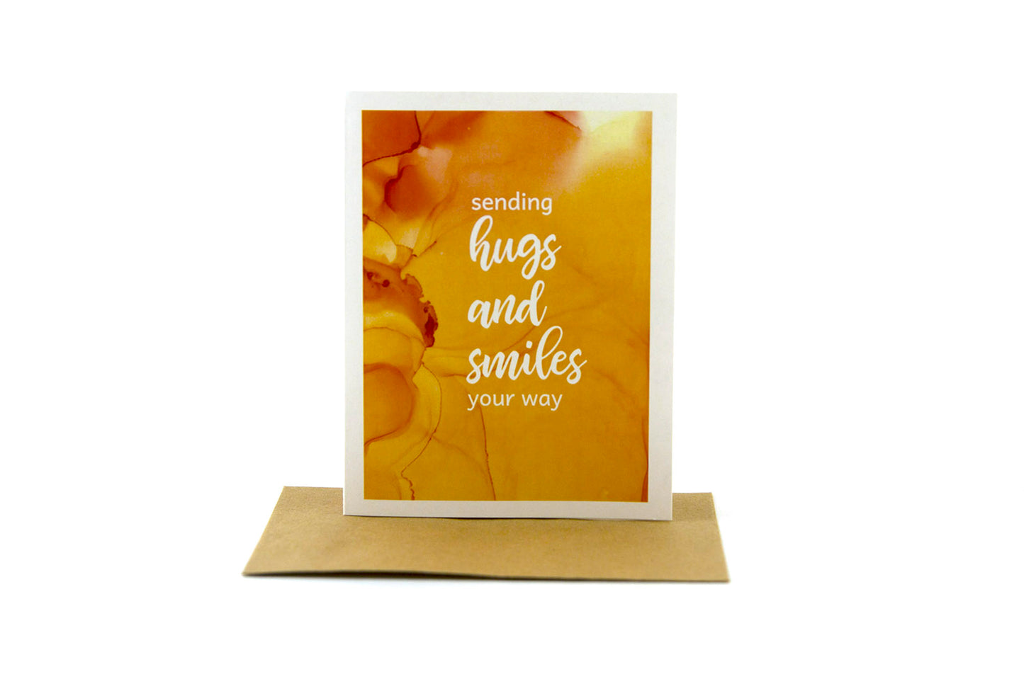 Greeting card standing upright on top of a kraft envelope against a white background.