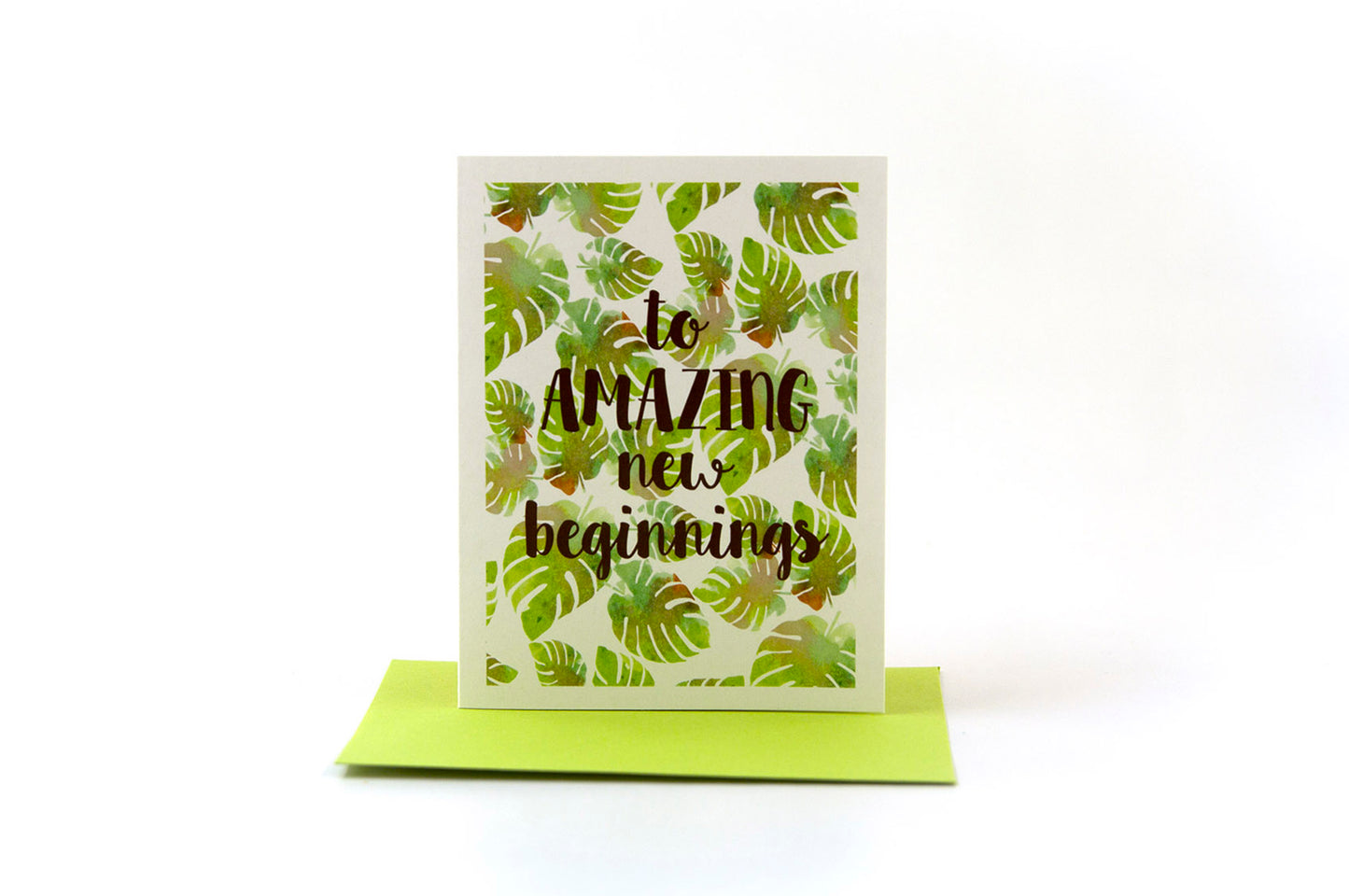 Greeting card standing upright on top of a colored envelope against a white background.