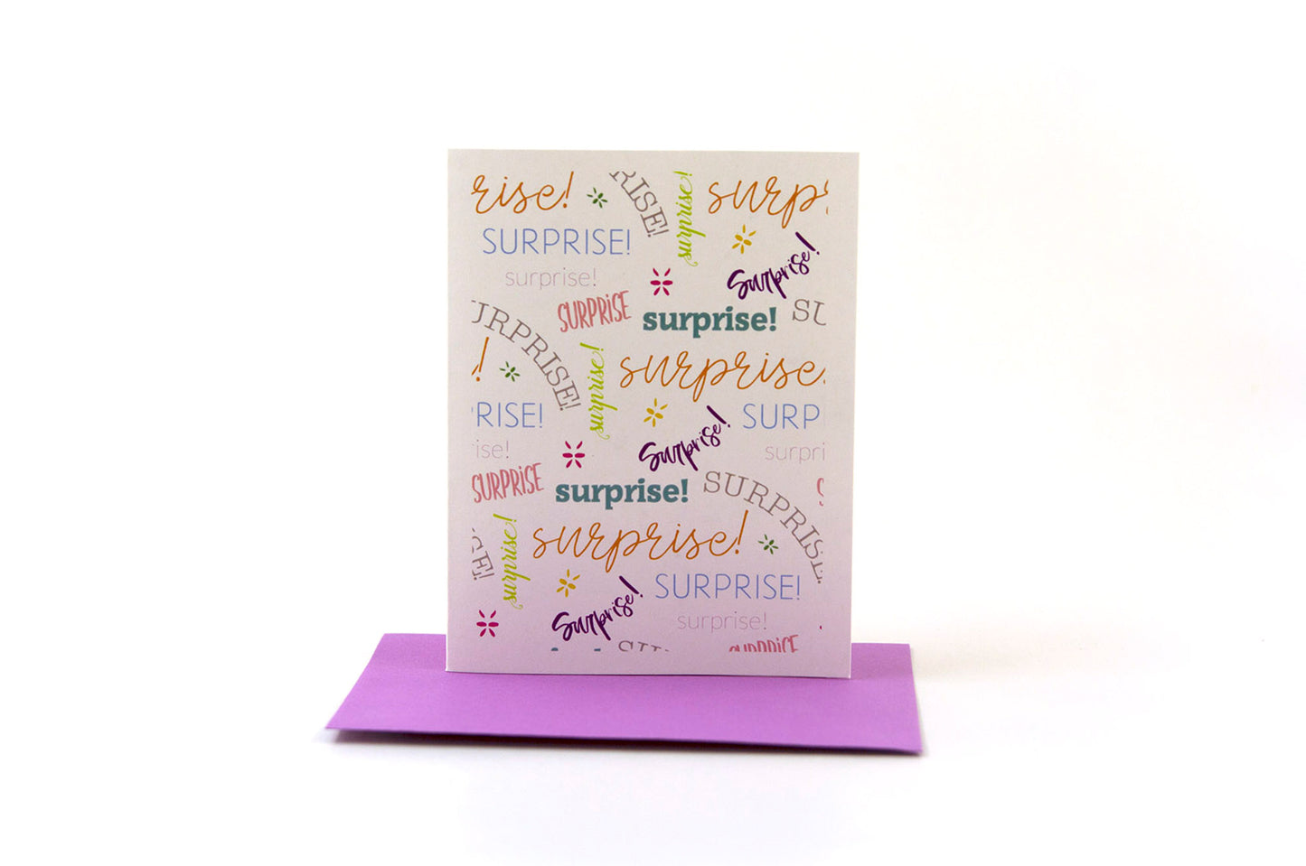 Greeting card standing upright on top of a colored envelope against a white background.