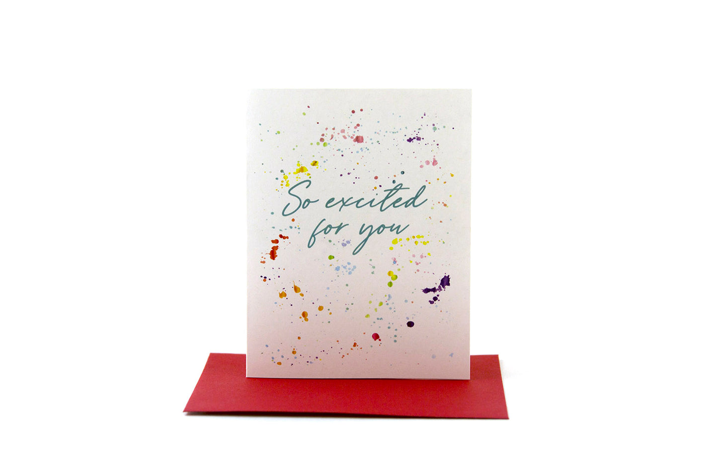 Greeting card standing upright on top of a colored envelope against a white background.