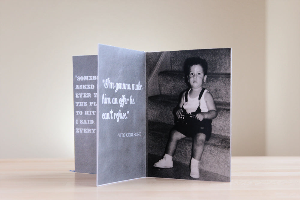 Centerpiece sitting on a wooden table with a neutral wall in the background. The chalkboard texture of the panels includes favorite quotes and the photo is of a toddler sitting on carpeted stairs looking at the camera.