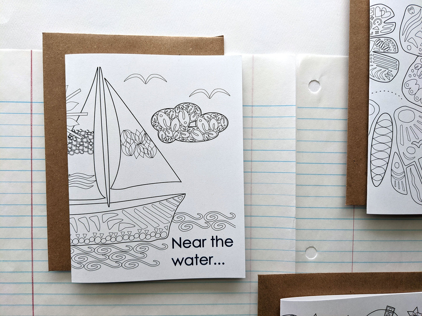 Three greeting cards laying on lined notebook paper.