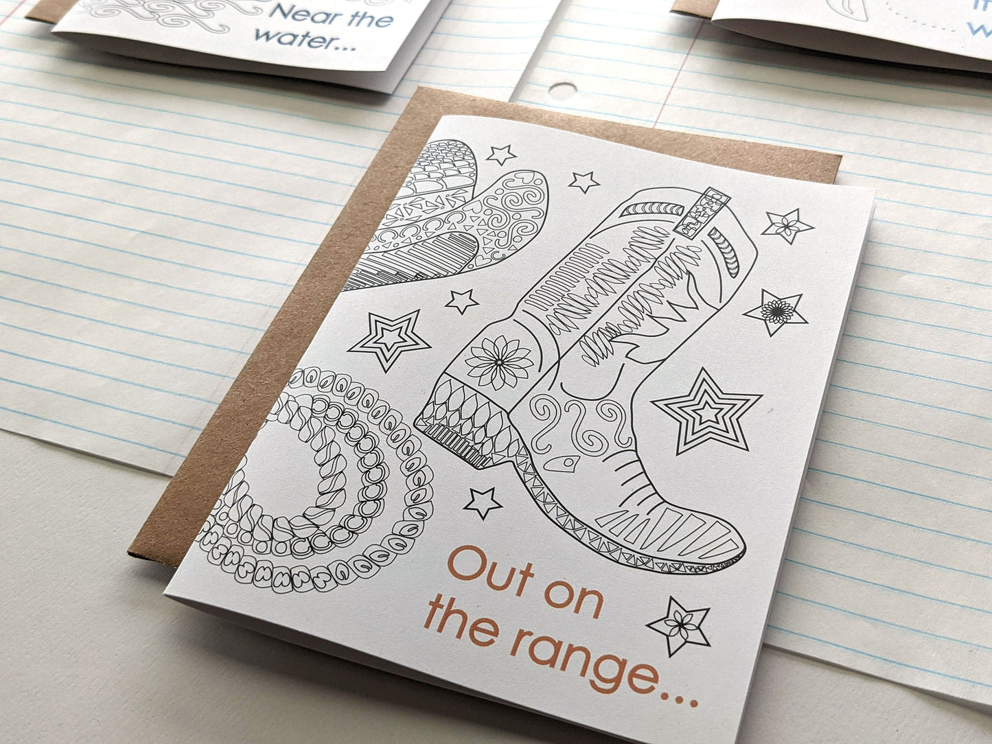 Angled view of greeting cards laying on lined notebook paper.