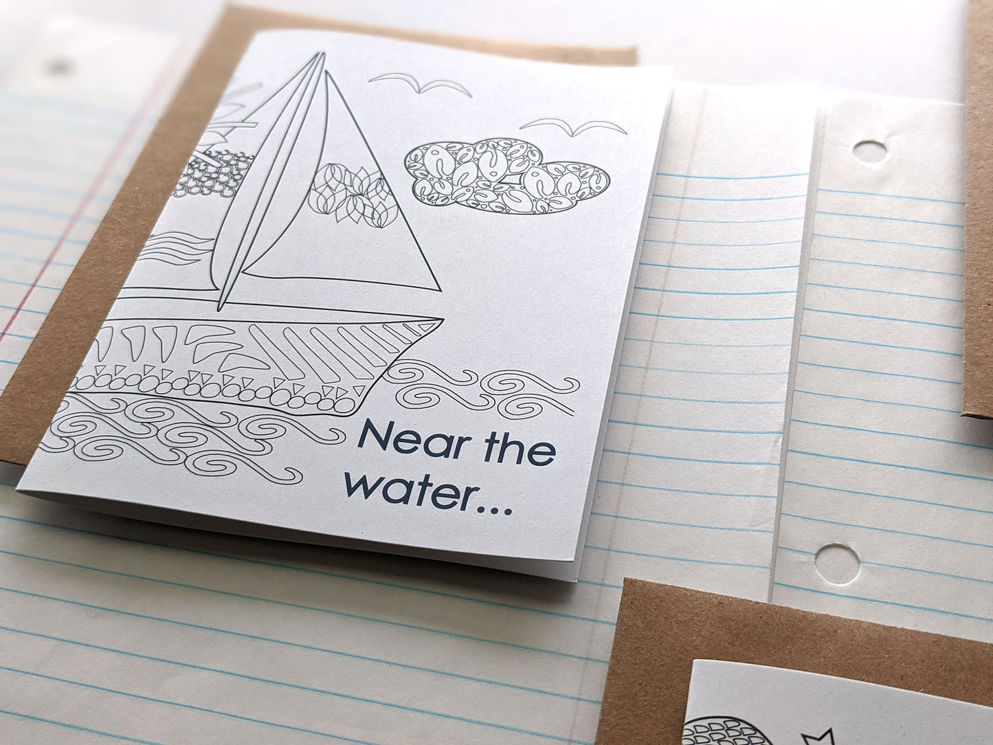 Angled view of greeting cards laying on lined notebook paper.