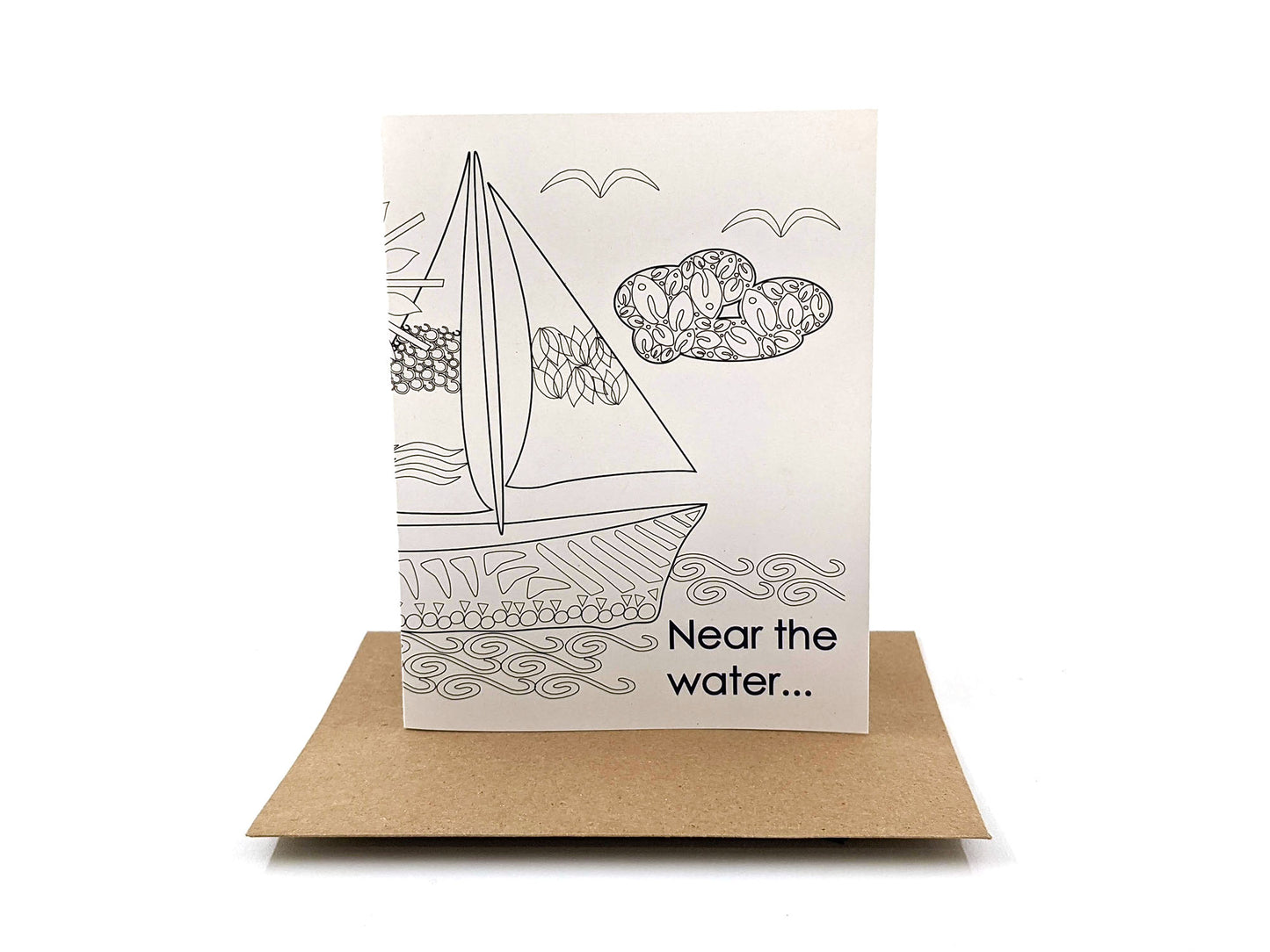 Greeting card standing upright on top of a kraft envelope against a white background.