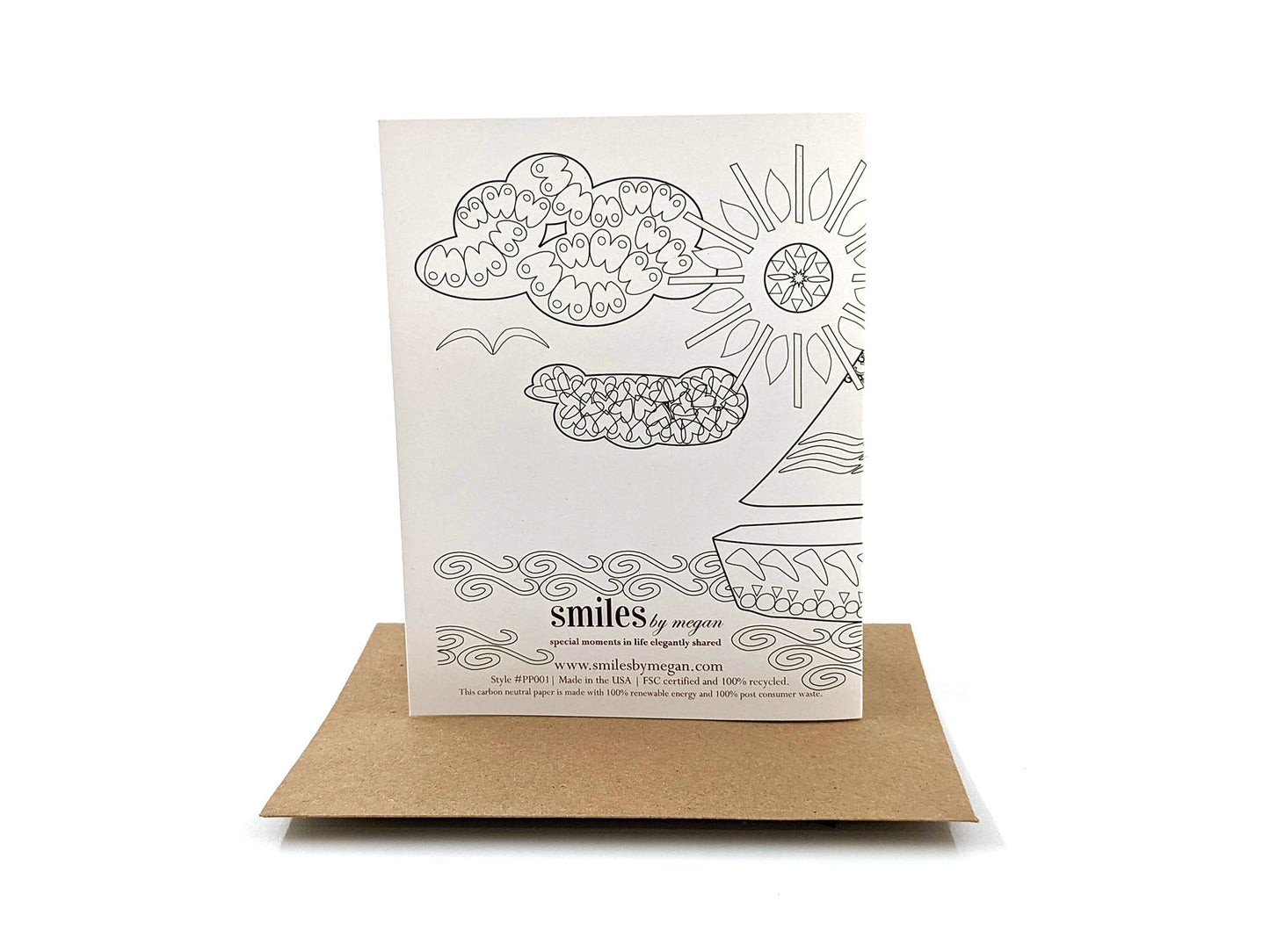 Back side of greeting card standing upright on top of a kraft envelope against a white background.