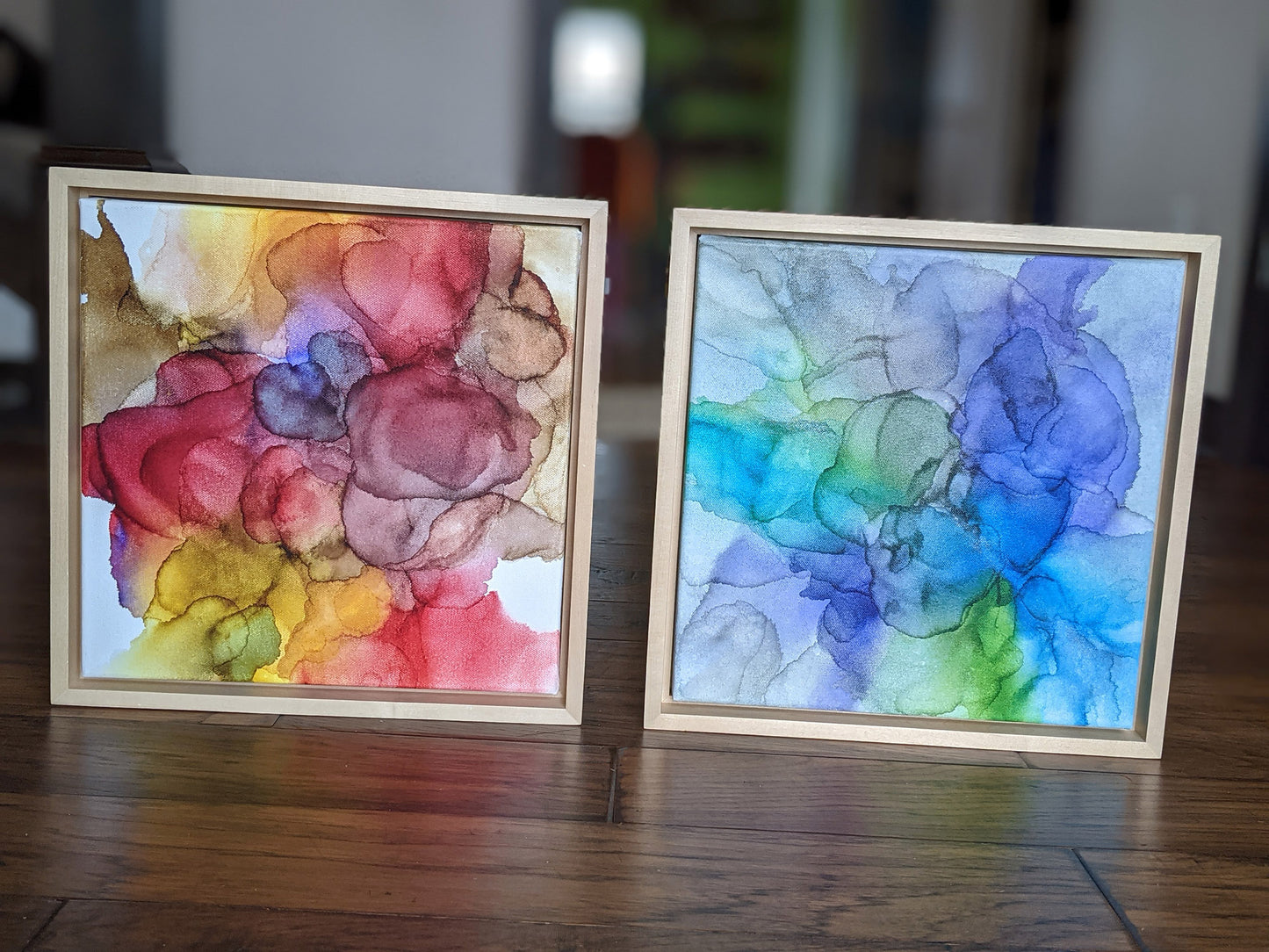 Front view of Perseverance and Abundance standing on a wood floor in a hallway set in light maple float frames.