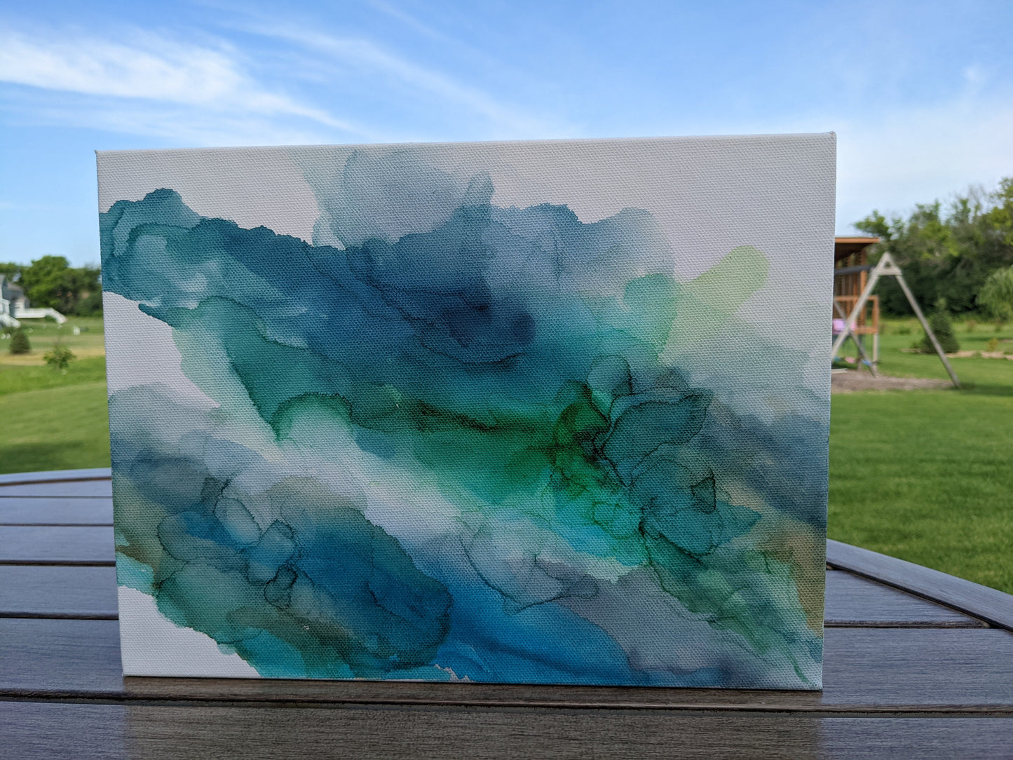 Front view of canvas standing on a slat patio table outdoors.