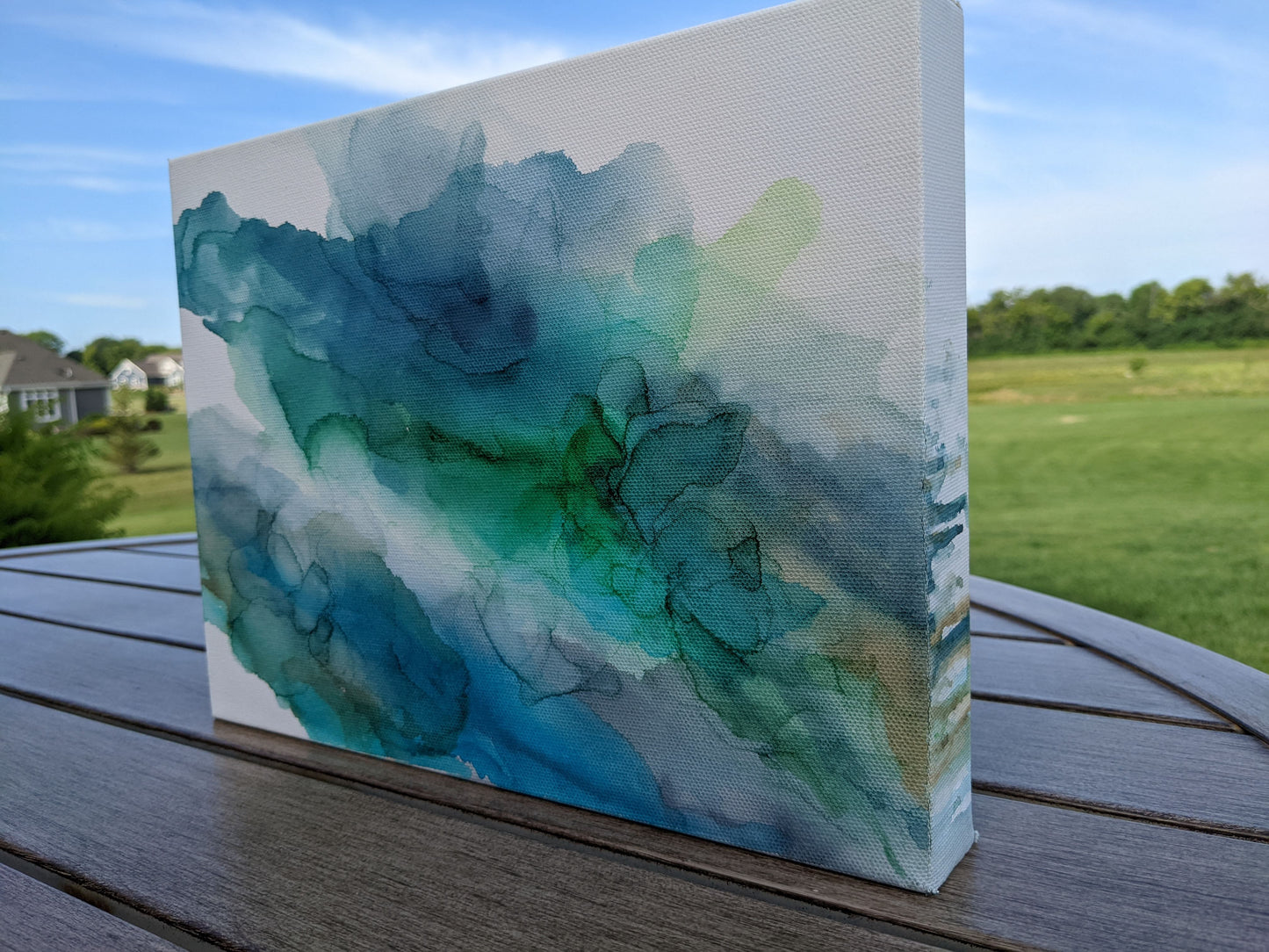Angled side view of canvas standing on a slat patio table outdoors.