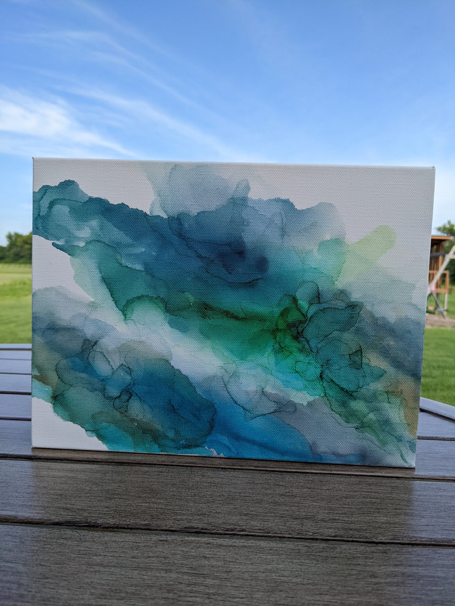 Front view of canvas standing on a slat patio table outdoors.