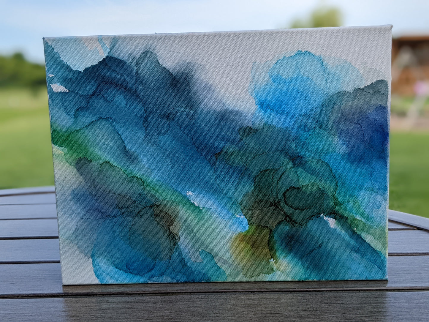 Front view of canvas standing on a slat patio table outdoors.