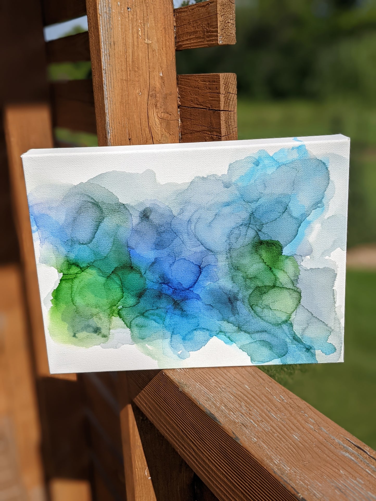 Front view of canvas standing on a slat patio table outdoors.