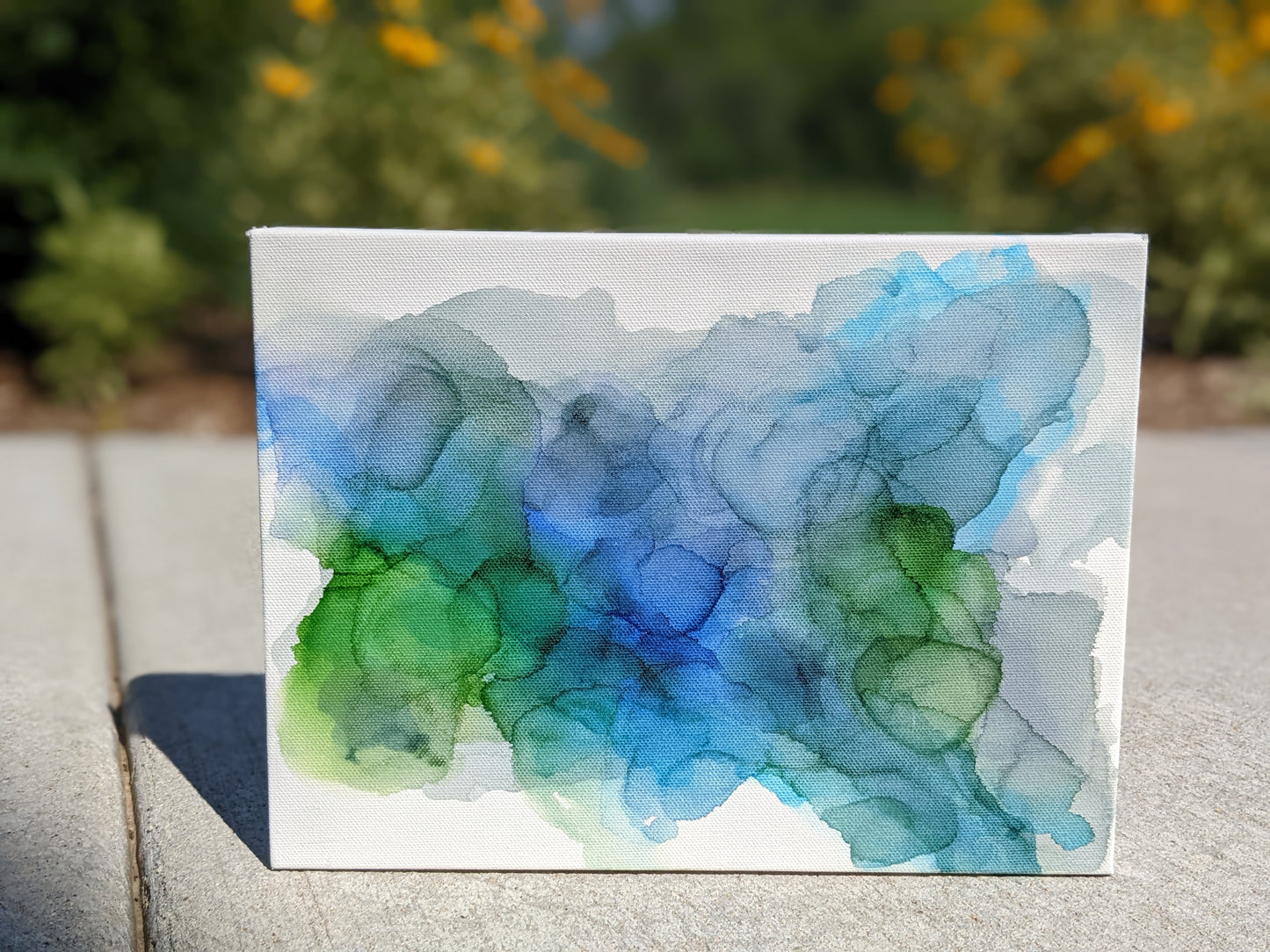 Front view of canvas sitting on concrete outdoors.