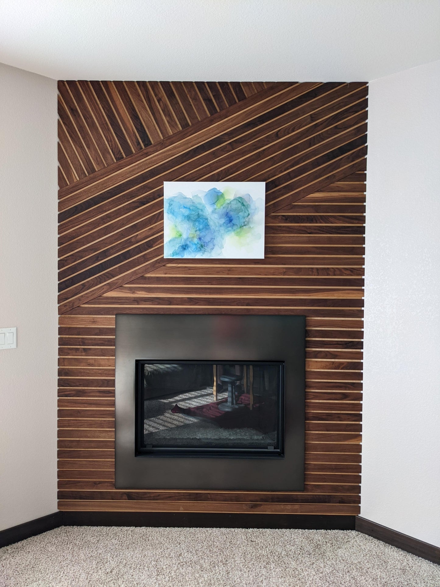 Canvas shown above a fireplace against a wood slat wall.