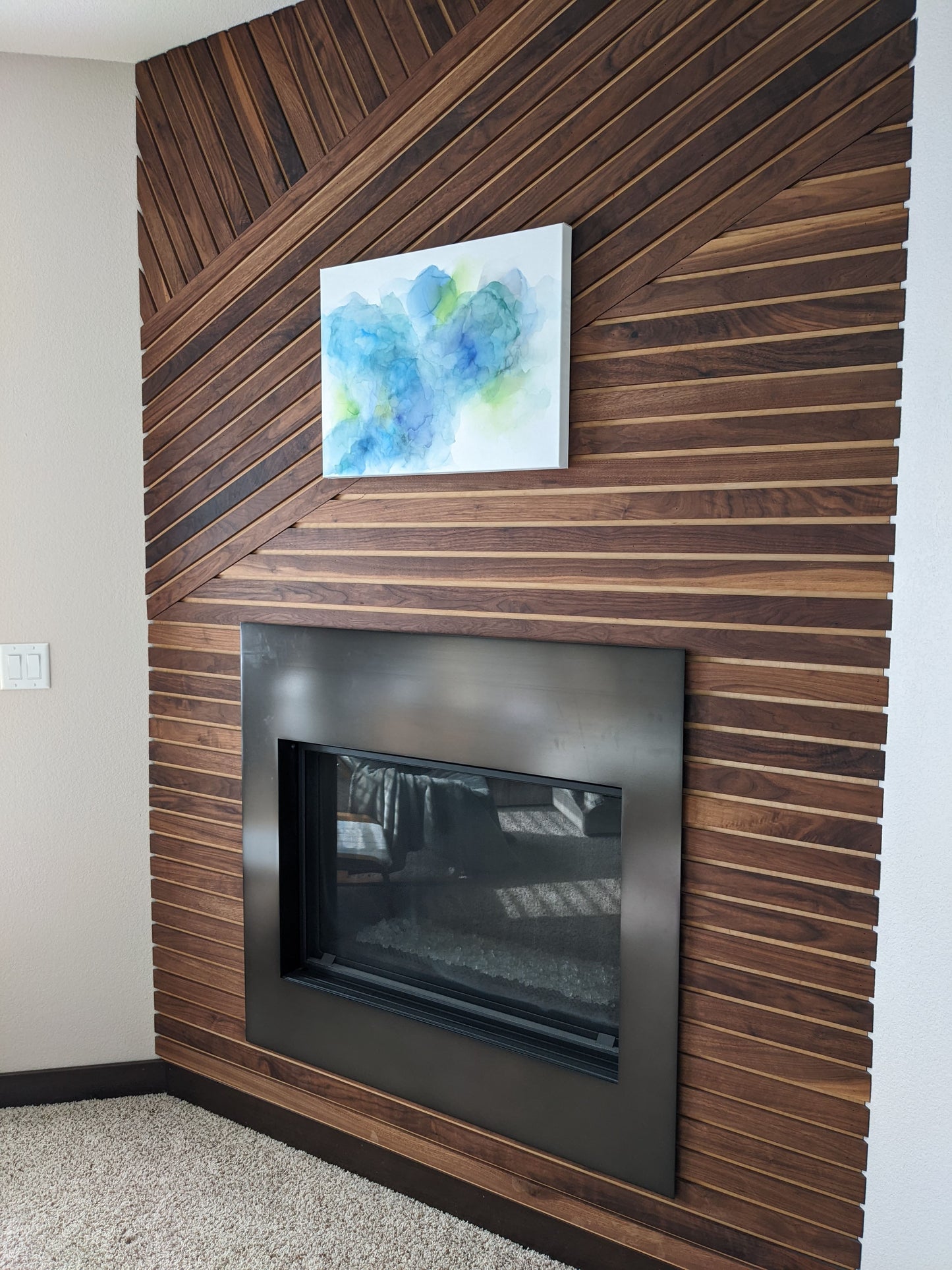 Angled side view of canvas hanging on a wood slat wall.