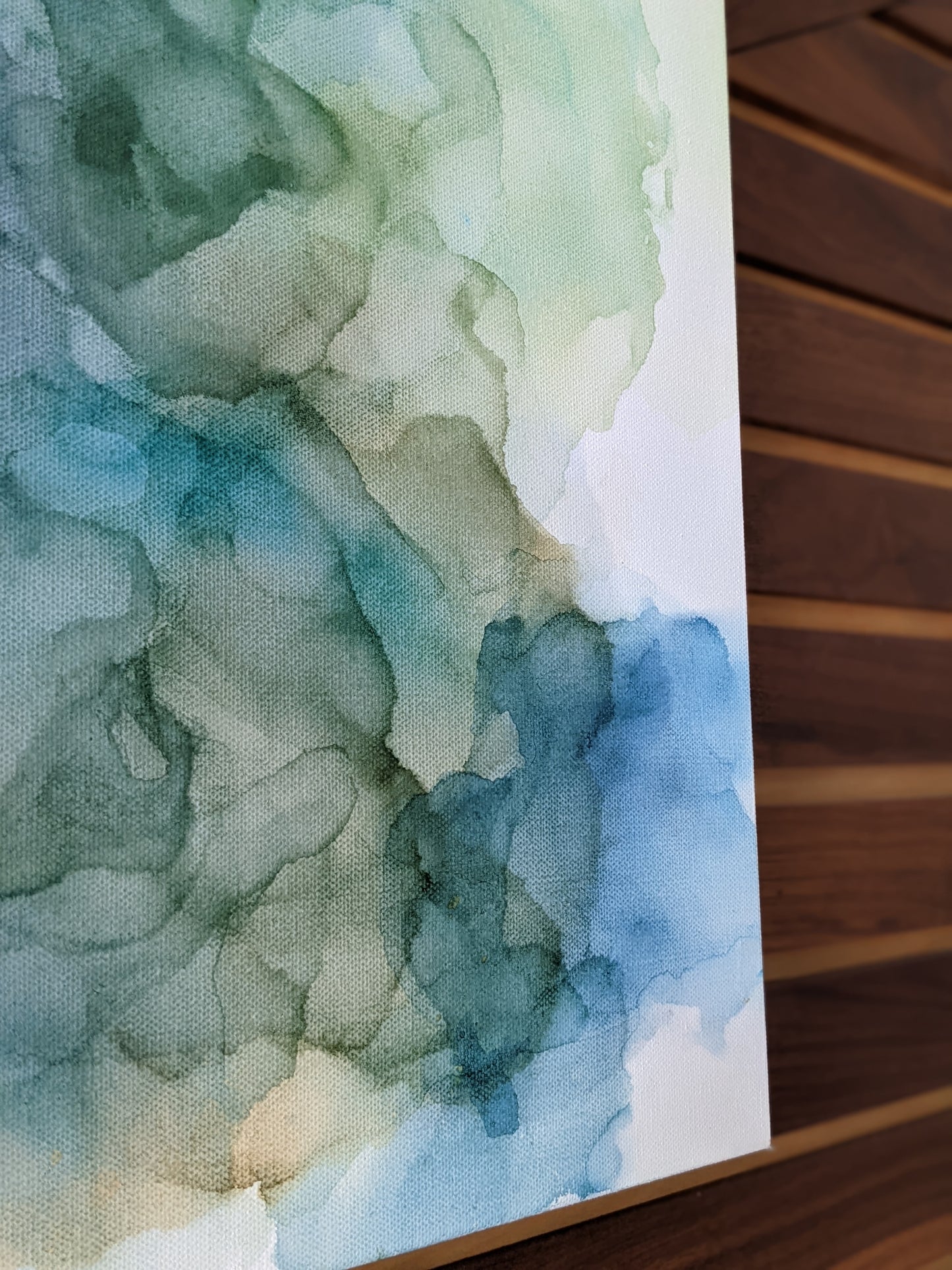 Detail of canvas shown against a wood slat wall.