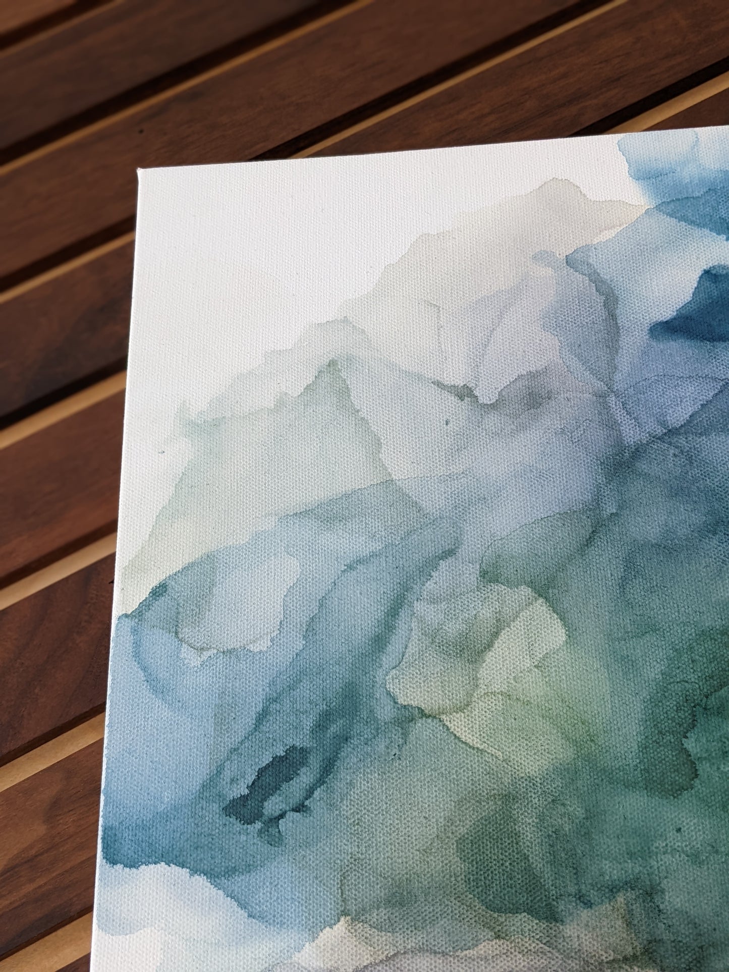 Detail of canvas shown against a wood slat wall.