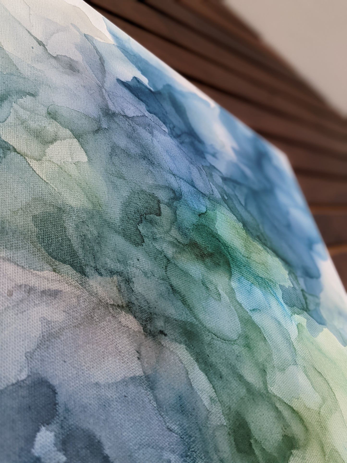 Detail of canvas shown against a wood slat wall.