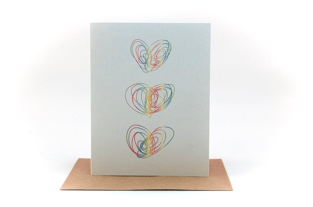 Greeting card standing upright on top of a kraaft envelope against a white background.