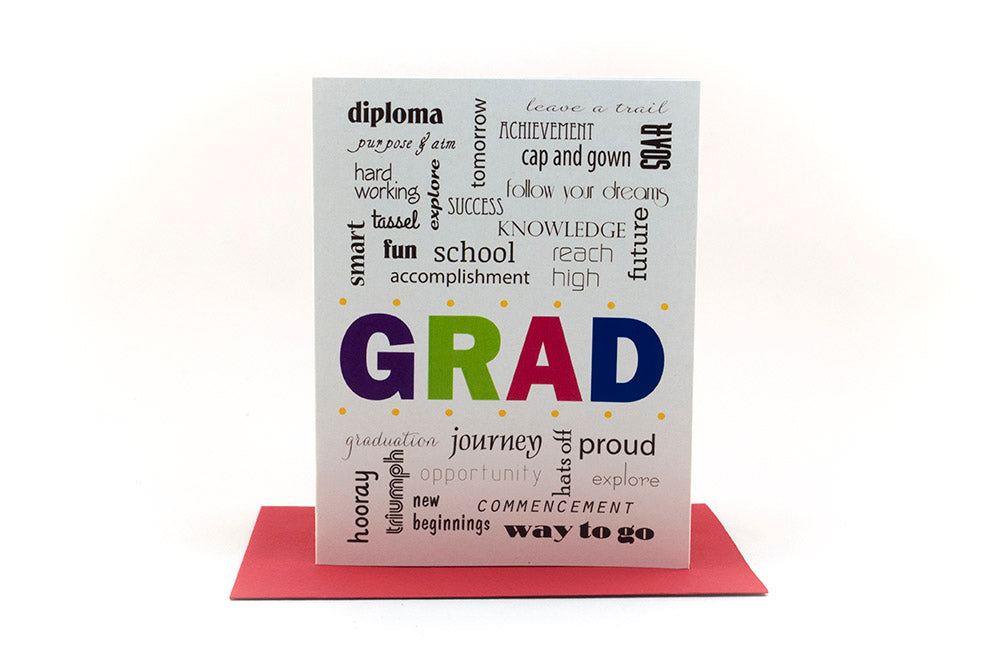 Greeting card standing upright on top of a colorful envelope against a white background.