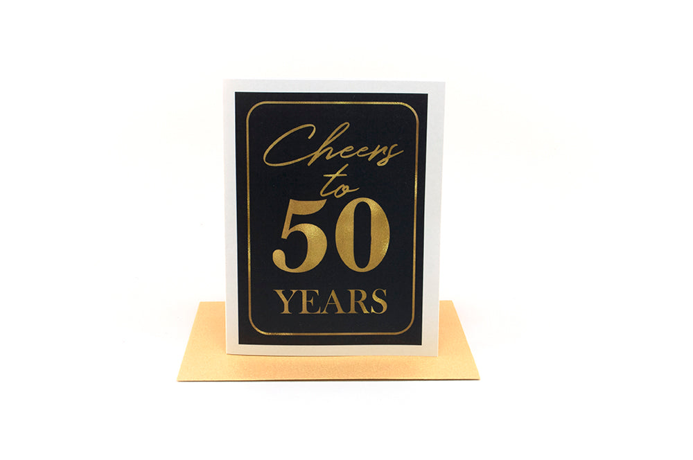 Greeting card standing upright on top of a colorful envelope against a white background.