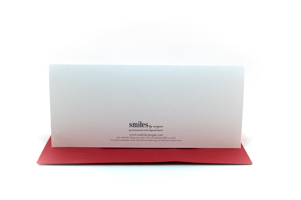 Back of greeting card standing upright on top of a colorful envelope against a white background.
