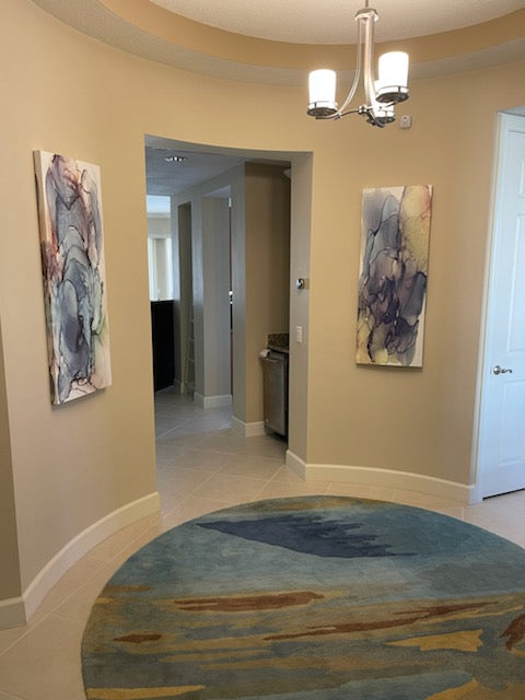 Painting printed on canvas shown hung on the wall in a home entry way.