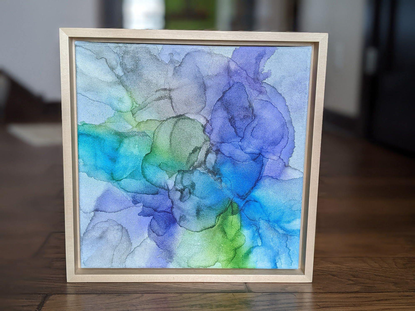 Front view of Perseverance standing on a wood floor in a hallway set in a light maple float frame.