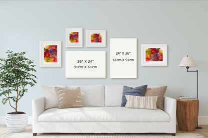 A staged living room scene showing a white sofa with decorative pillows, a potted plant, a floor lamp, and five framed wall art prints arranged above the couch. 