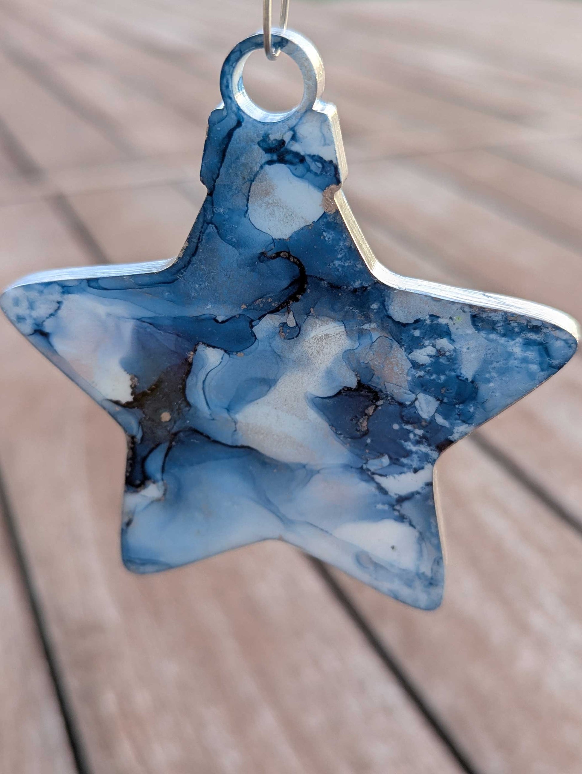 Star-shaped blue and white marbled ornament on a wooden surface