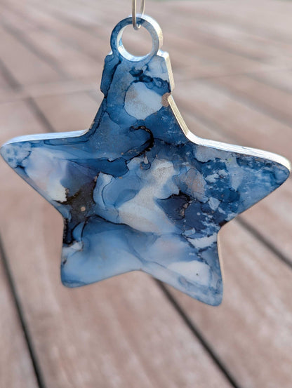 Star-shaped blue and white marbled ornament on a wooden surface