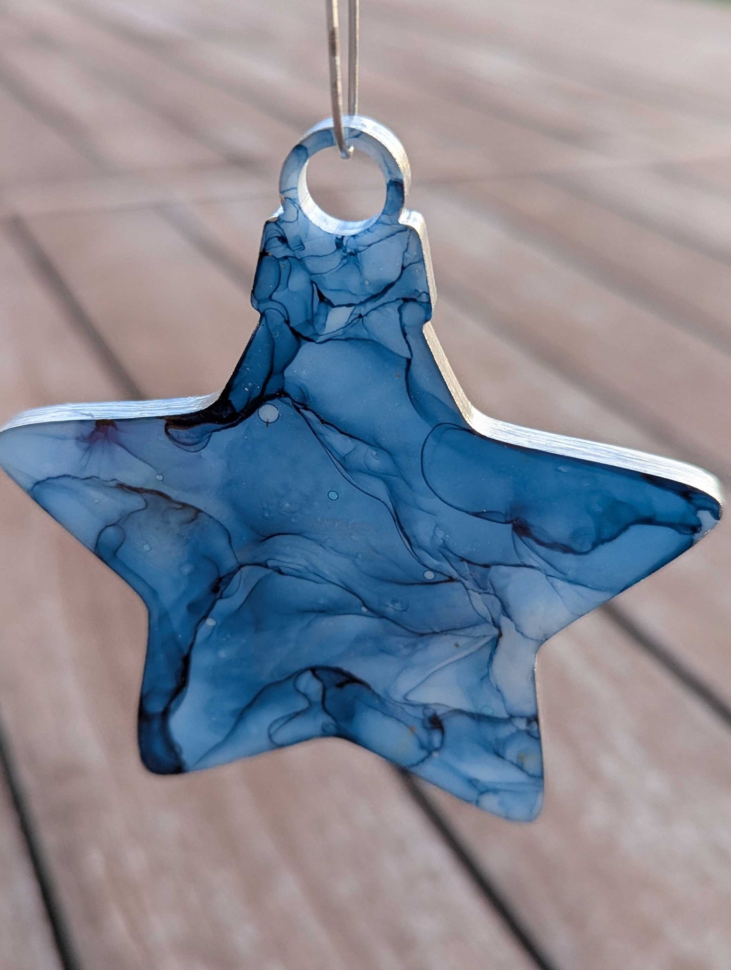 Blue marbled star-shaped object on a wooden surface