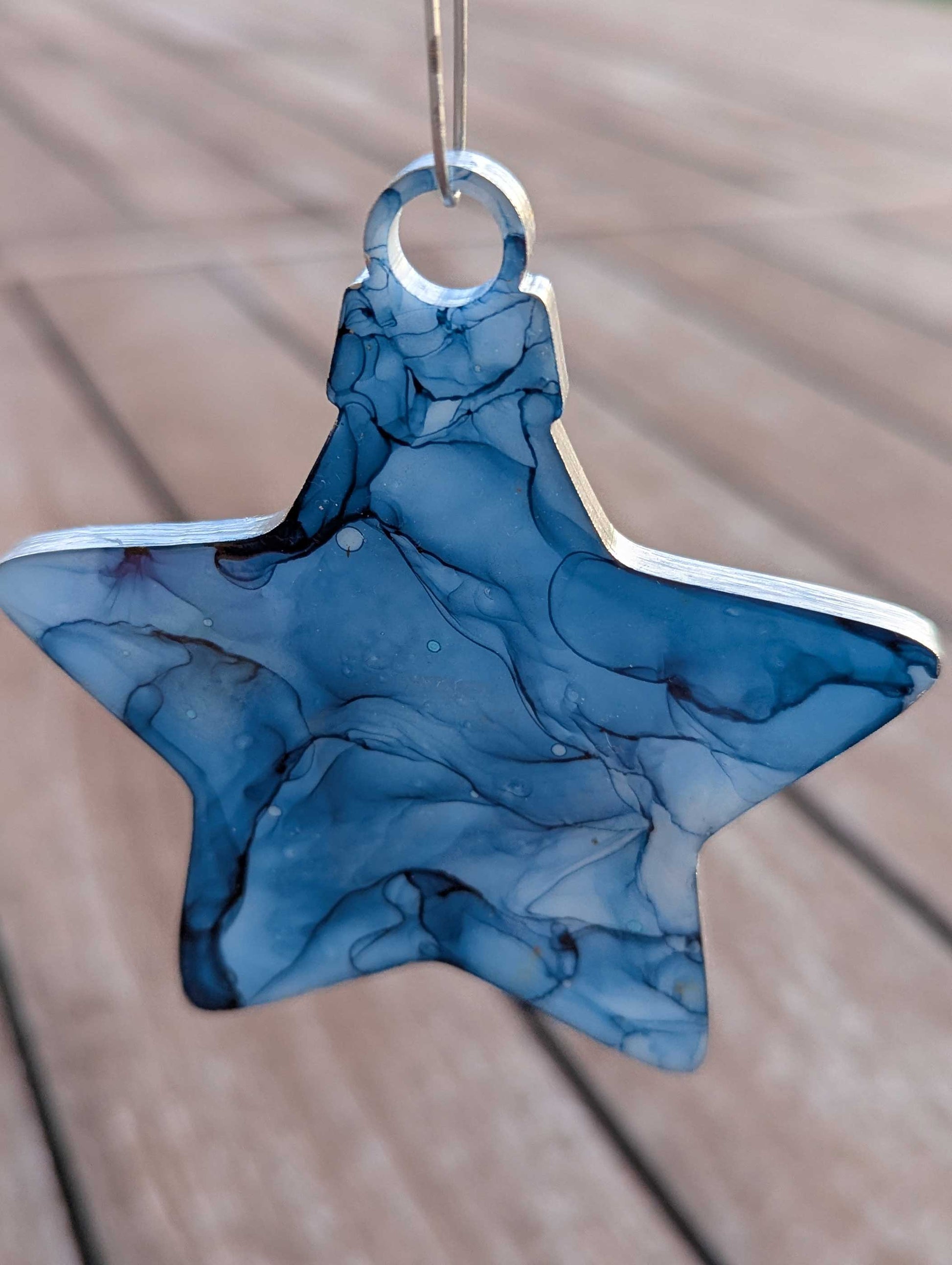 Blue marbled star-shaped object on a wooden surface