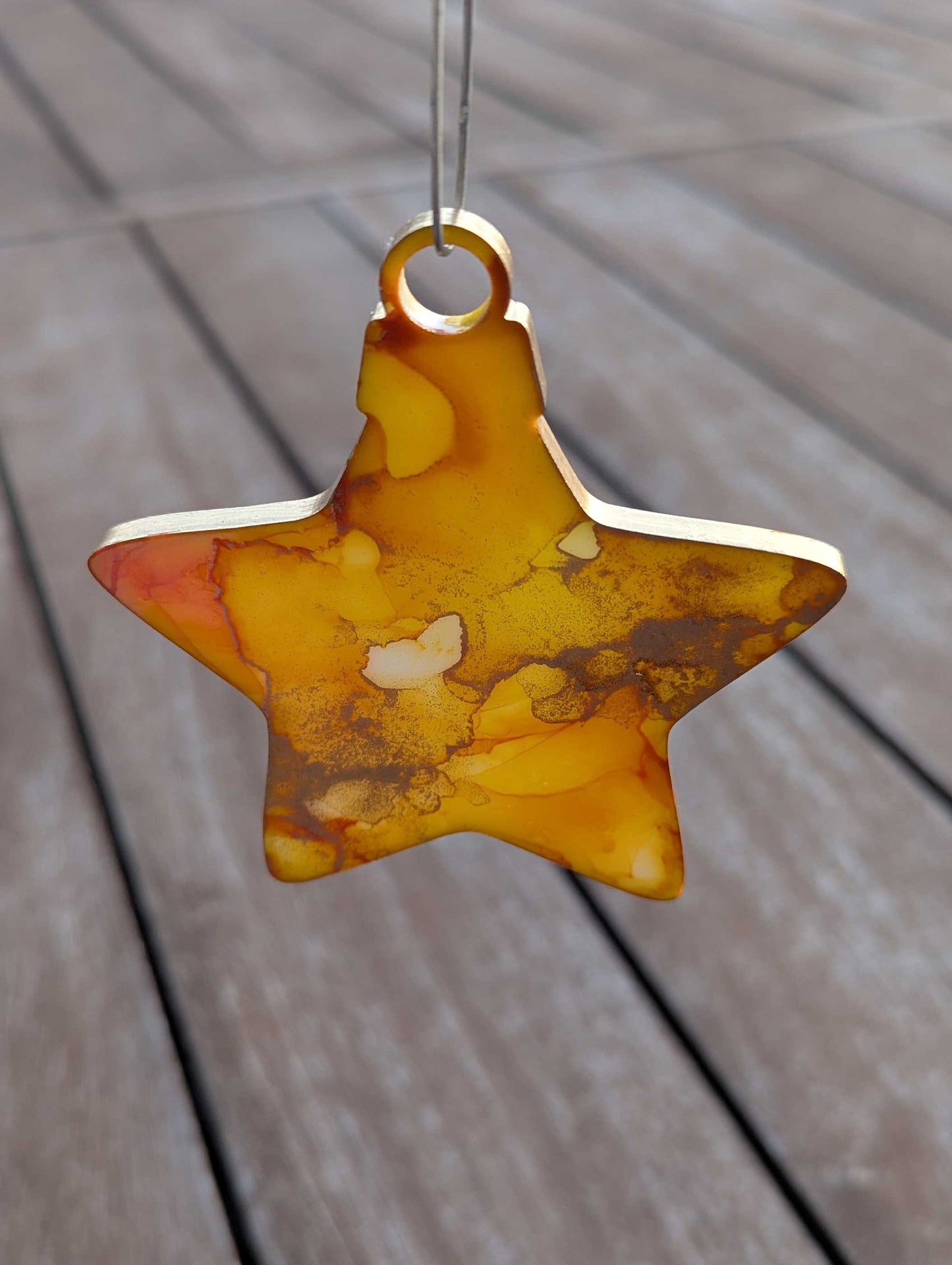 Star-shaped decorative item with a marbled design on a wooden surface